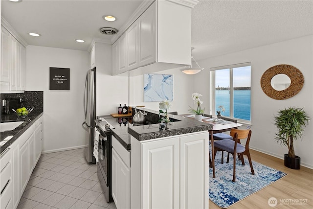 733 S Lake St Unit 312, Kirkland, WA 98033 - kitchen featuring freestanding refrigerator, white cabinetry, tile counters, a water view, and recessed lighting