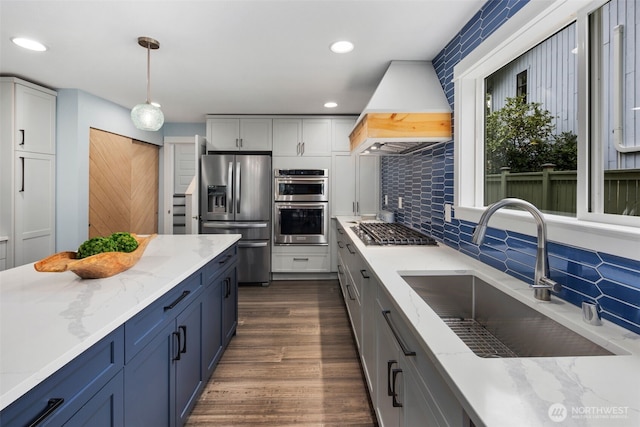 6540 159th Ave NE, Redmond, WA 98052 - kitchen with light stone countertops, appliances with stainless steel finishes, a sink, custom range hood, and tasteful backsplash