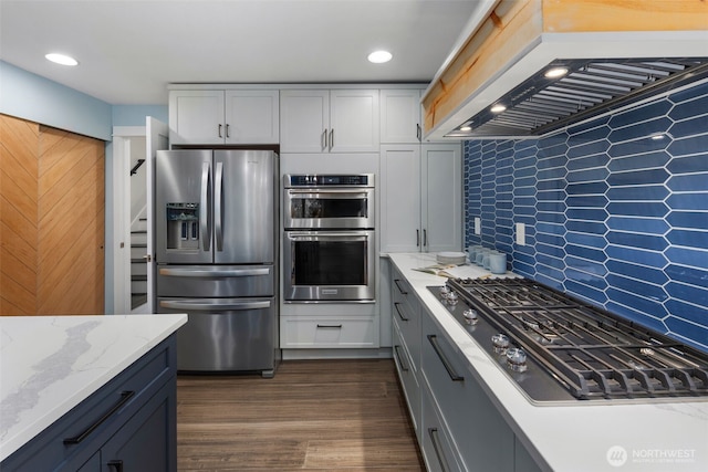 6540 159th Ave NE, Redmond, WA 98052 - kitchen with appliances with stainless steel finishes, light stone counters, decorative backsplash, dark wood-type flooring, and custom exhaust hood