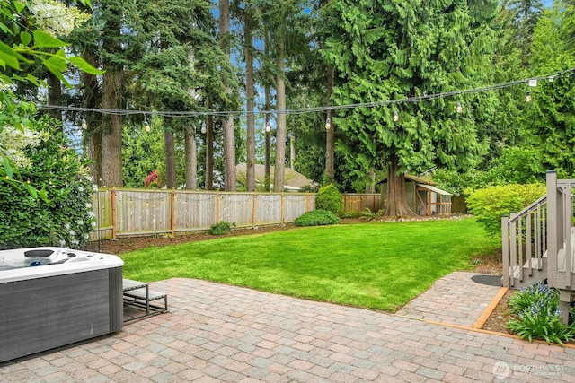 view of patio / terrace featuring a fenced backyard, an outdoor structure, a hot tub, and central AC