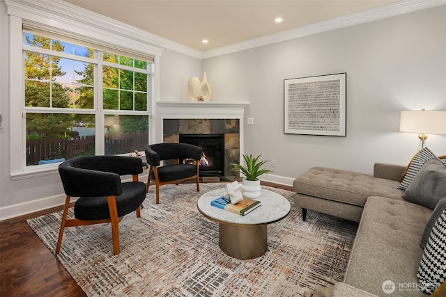 living area with baseboards, a fireplace, wood finished floors, crown molding, and recessed lighting