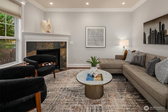 living area with recessed lighting, ornamental molding, a tile fireplace, baseboards, and wood finished floors