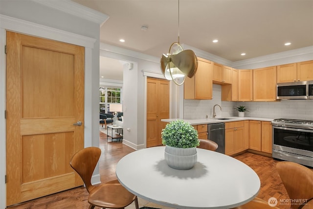 kitchen featuring appliances with stainless steel finishes, light brown cabinets, dark wood-style floors, backsplash, and crown molding