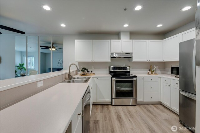 kitchen with a sink, stainless steel appliances, white cabinetry, and under cabinet range hood