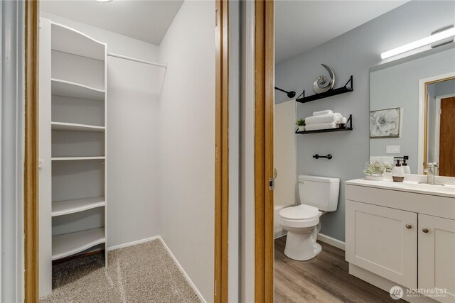 full bath with toilet, baseboards, washtub / shower combination, and vanity