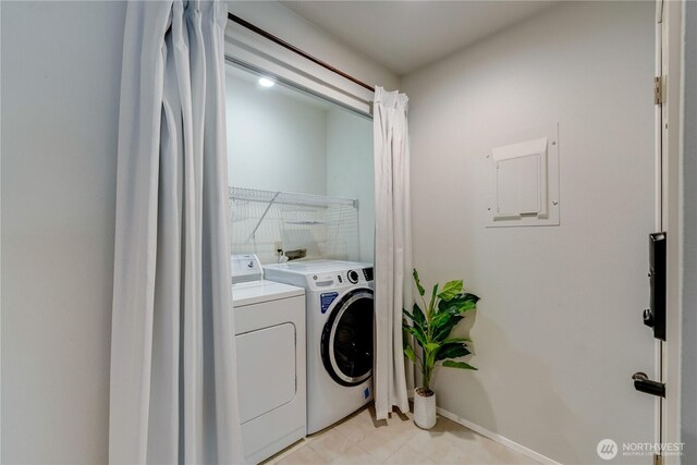 clothes washing area featuring baseboards, laundry area, and washing machine and clothes dryer