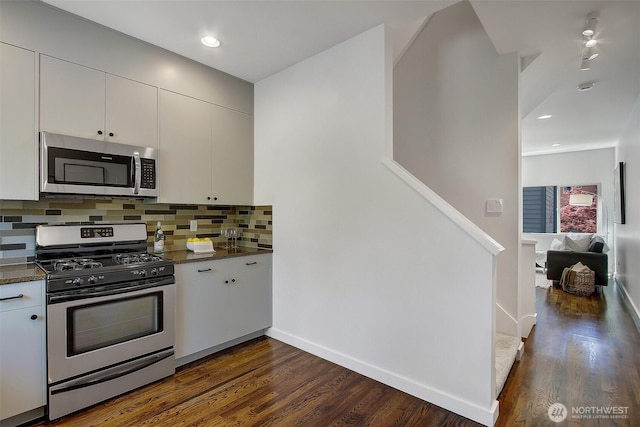 kitchen featuring backsplash, stainless steel appliances, white cabinets, and dark wood-type flooring