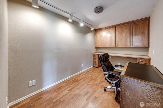 home office featuring baseboards, track lighting, and light wood-style floors