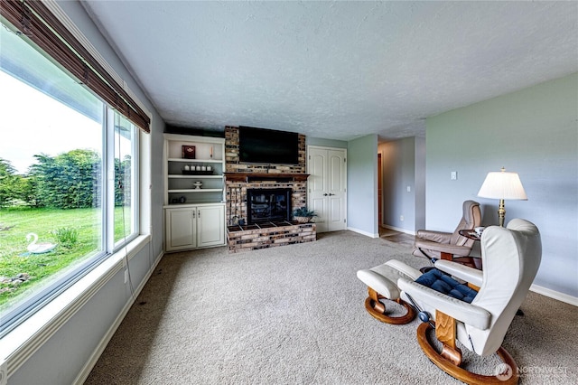 carpeted living room with a brick fireplace, a textured ceiling, and baseboards