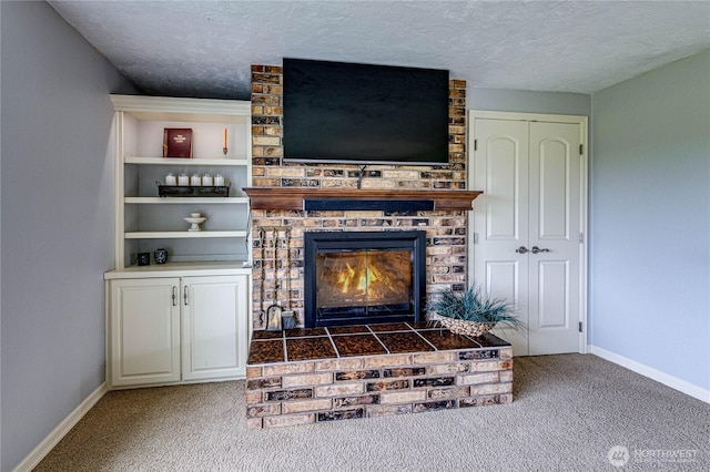 interior details featuring baseboards, carpet, a brick fireplace, and a textured ceiling