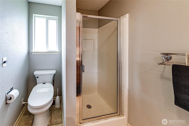 full bath featuring baseboards, a stall shower, and toilet