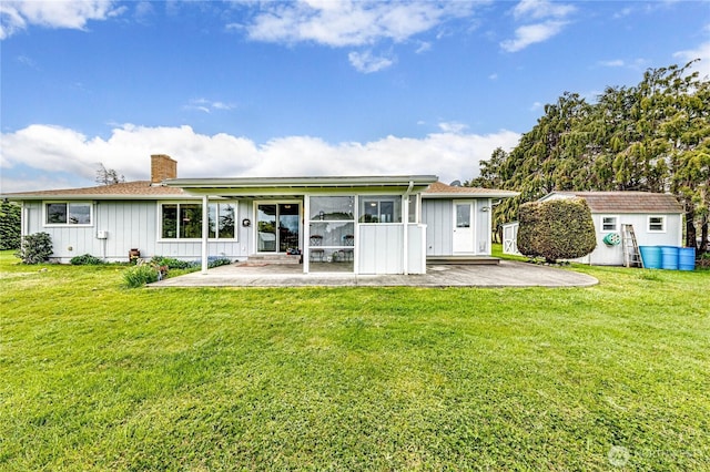 rear view of property with an outdoor structure, board and batten siding, a chimney, and a patio area