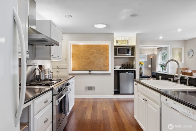 15825 10th Ave SW, Burien, WA 98166 - kitchen with appliances with stainless steel finishes, a sink, wall chimney exhaust hood, dark wood-style floors, and dark countertops