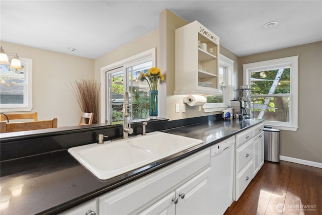15825 10th Ave SW, Burien, WA 98166 - kitchen with white dishwasher, a sink, white cabinets, dark wood finished floors, and baseboards