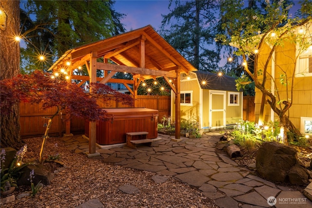15825 10th Ave SW, Burien, WA 98166 - patio terrace at dusk featuring a hot tub, a patio area, a gazebo, and a fenced backyard