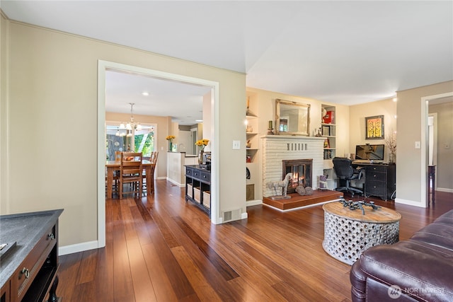 15825 10th Ave SW, Burien, WA 98166 - living room with a chandelier, a brick fireplace, dark wood finished floors, and baseboards