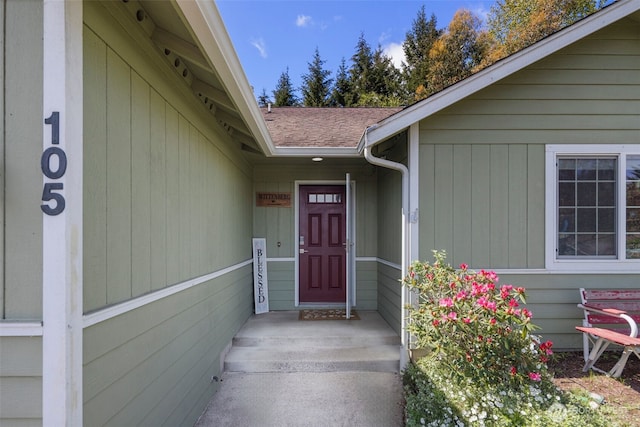 entrance to property featuring a shingled roof