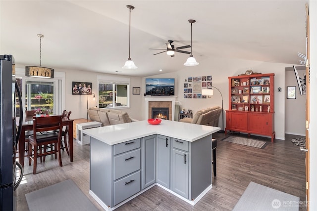 kitchen featuring a ceiling fan, gray cabinetry, freestanding refrigerator, open floor plan, and lofted ceiling