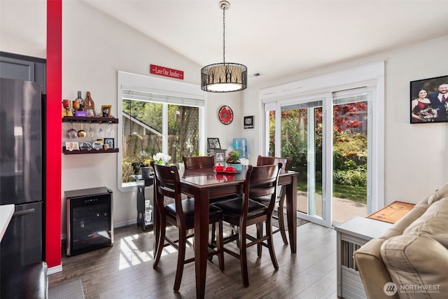 dining space with wood finished floors and vaulted ceiling