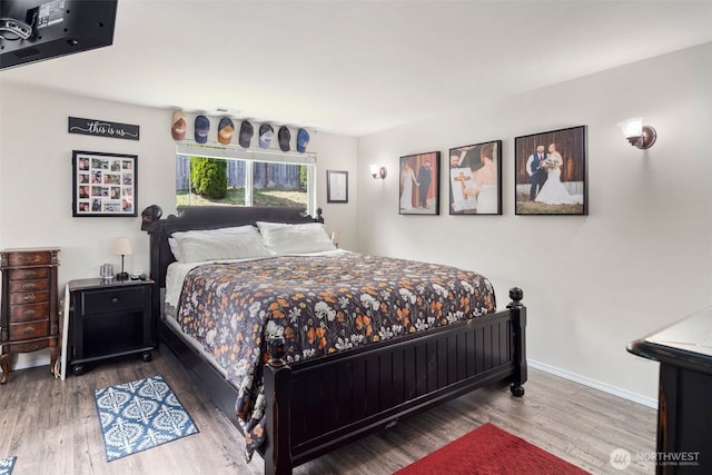 bedroom with baseboards and wood finished floors