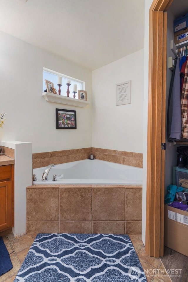full bathroom featuring vanity, tile patterned flooring, and a bath