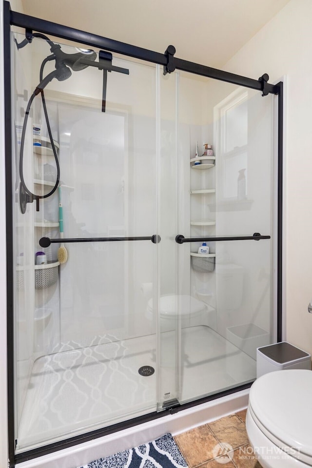 bathroom featuring a shower stall and toilet
