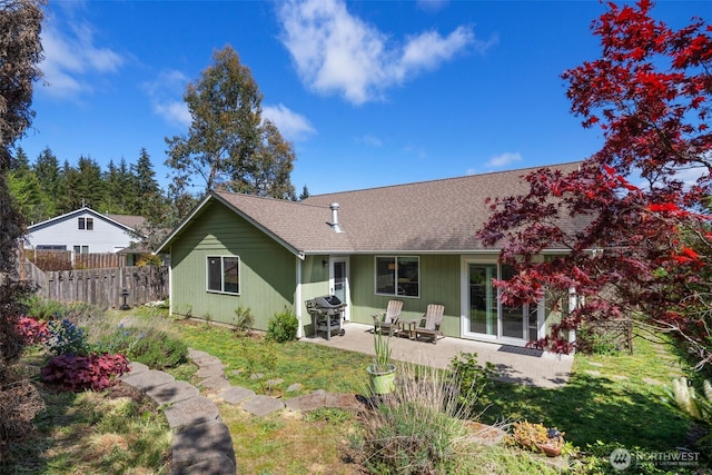 rear view of property with a patio, fence, and roof with shingles
