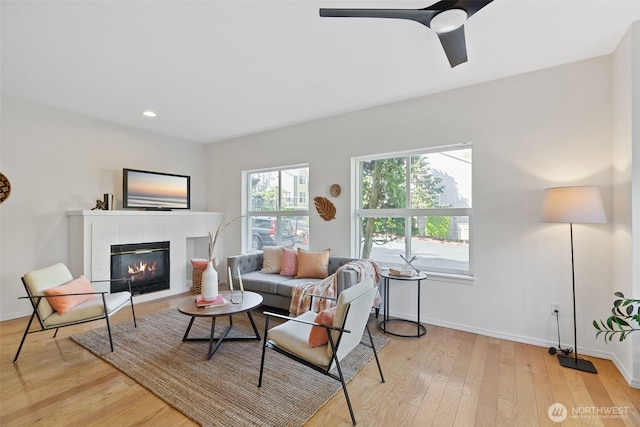 living room with light wood-style flooring, a fireplace, baseboards, recessed lighting, and a ceiling fan