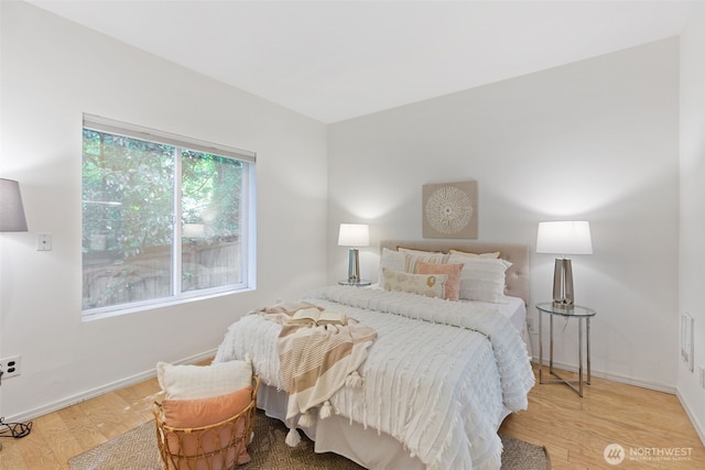 bedroom featuring light wood finished floors and baseboards
