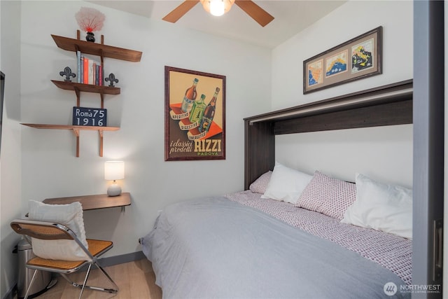 bedroom featuring a ceiling fan, baseboards, and wood finished floors