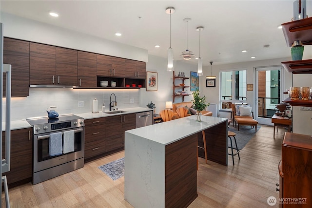 kitchen with open shelves, modern cabinets, a sink, light wood finished floors, and appliances with stainless steel finishes