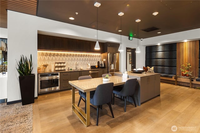kitchen with visible vents, a sink, light wood-type flooring, and stainless steel appliances