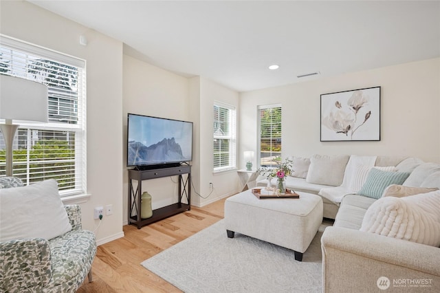 living room with visible vents, recessed lighting, baseboards, and light wood-type flooring