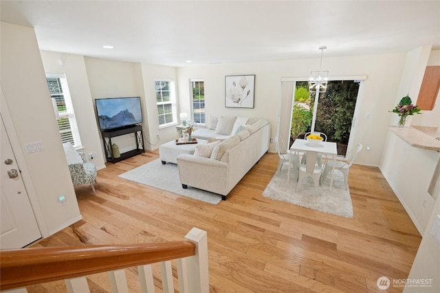 living area featuring plenty of natural light, recessed lighting, light wood-style flooring, and baseboards