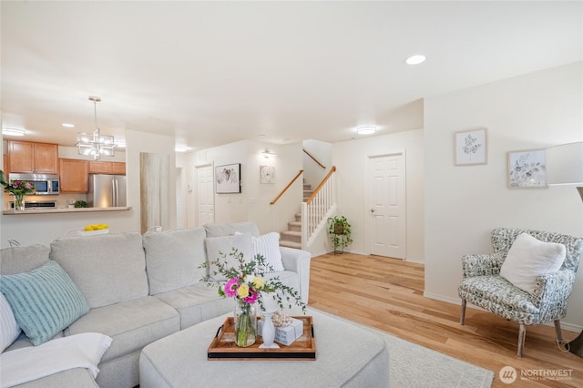 living area with light wood finished floors, a chandelier, stairs, recessed lighting, and baseboards