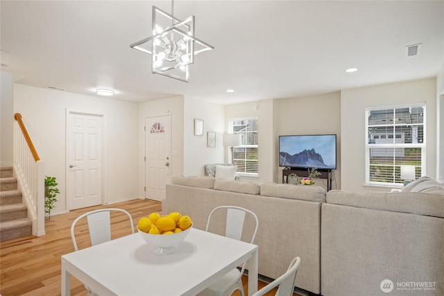 dining room with stairway, plenty of natural light, light wood-type flooring, and visible vents
