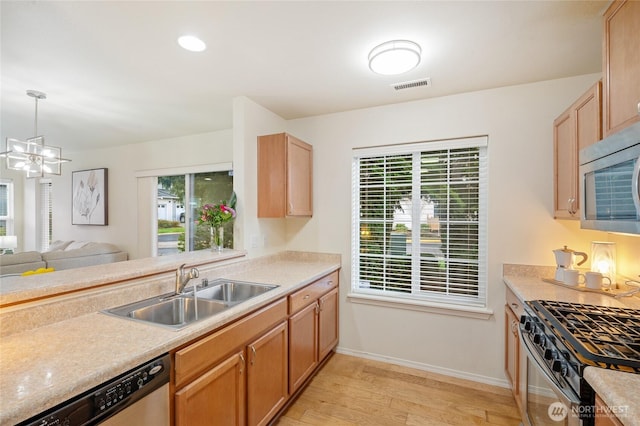 kitchen with a healthy amount of sunlight, visible vents, appliances with stainless steel finishes, a sink, and light wood-style floors