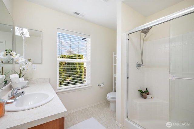 full bath with visible vents, a shower stall, vanity, baseboards, and toilet
