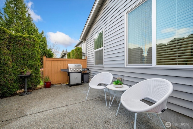 view of patio with fence and a grill