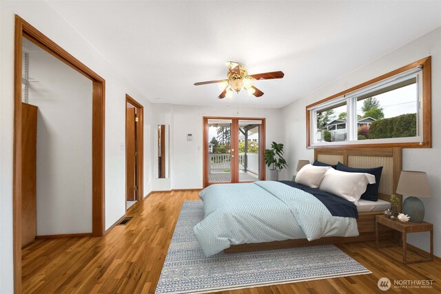 bedroom featuring ceiling fan, visible vents, access to exterior, and light wood finished floors