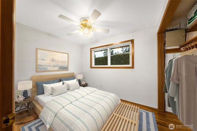 bedroom with a ceiling fan, baseboards, and wood finished floors