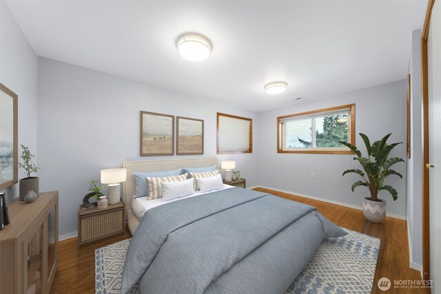 bedroom with baseboards and wood finished floors