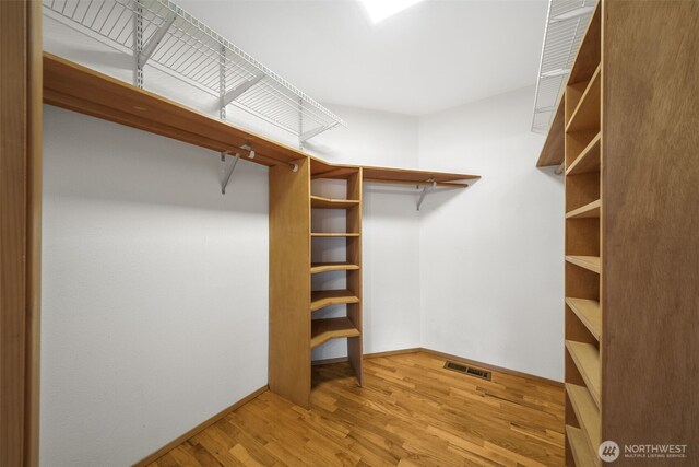walk in closet featuring wood finished floors and visible vents