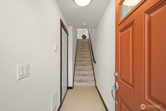 hall featuring baseboards, visible vents, and stairway