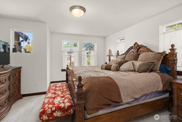 bedroom with baseboards and light colored carpet
