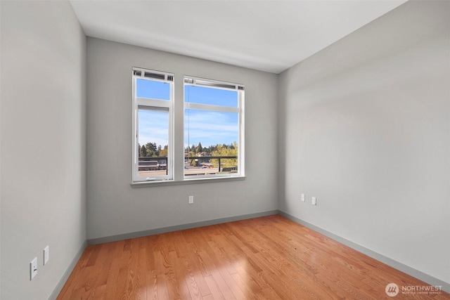 empty room with light wood-style flooring and baseboards