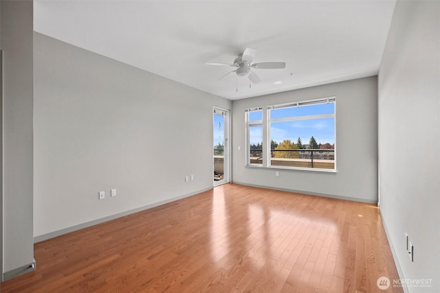 empty room featuring a ceiling fan, wood finished floors, and baseboards