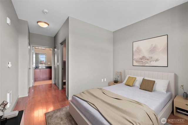bedroom with wood finished floors and baseboards