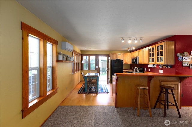 166 White Point Rd, Friday Harbor, WA 98250 - kitchen featuring a peninsula, glass insert cabinets, stainless steel microwave, a wall unit AC, and a breakfast bar area