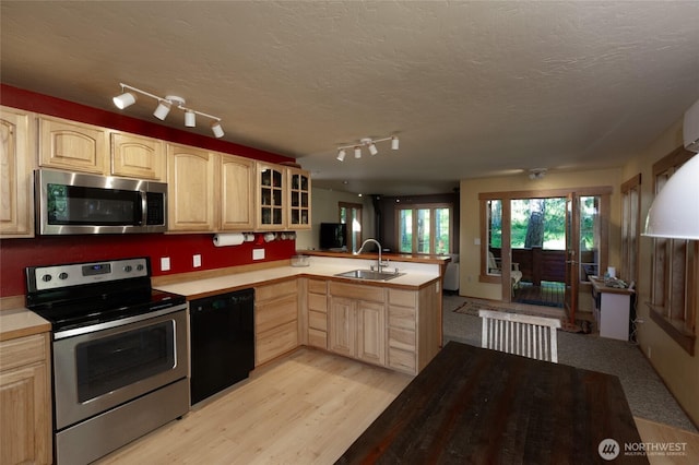 166 White Point Rd, Friday Harbor, WA 98250 - kitchen with stainless steel appliances, light brown cabinetry, a sink, a peninsula, and a textured ceiling